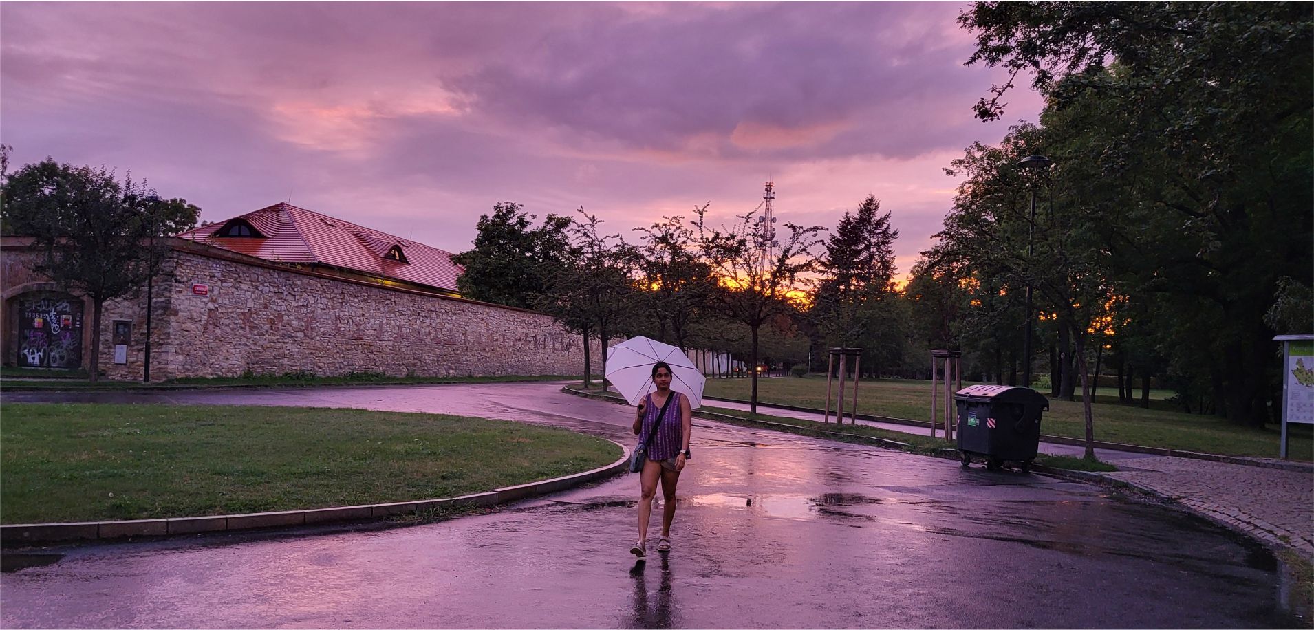 A woman holding a white umbrella in a calm, scenic setting, representing focus and clarity in how Ideas to Reach approaches digital marketing services.